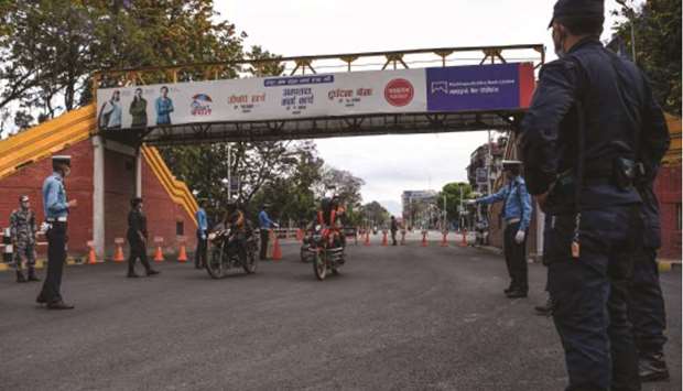 Police personnel check motorists during a government-imposed nationwide lockdown as a preventive measure against the coronavirus, on a deserted road in Kathmandu yesterday.