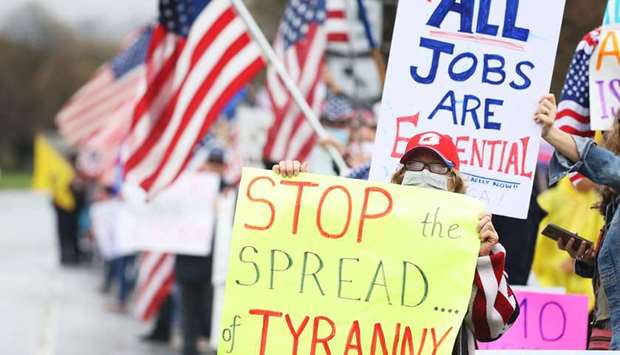 Protesters hold signs during the Re-Open America rally on May 1 in Commack, New York.