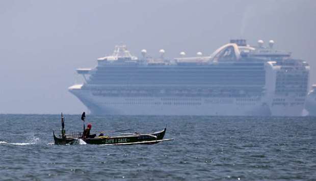 A fishing boat sails past the Princess Cruises' Ruby Princess cruise ship as it docks in Manila Bay during the spread of the coronavirus disease (COVID-19), in Cavite city, Philippines