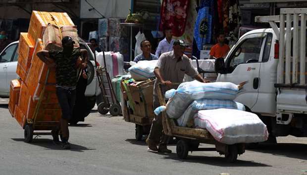 Workers transport merchandise piled on carts outside the Shorja market in Baghdad on May 4. Iraq is seeking financial aid from the US and is said to have asked the International Monetary Fund for a deferral of payments on some $546mn in loans. Its Eurobond yields average 15.7%, easily the highest among Middle Eastern governments, according to Bloomberg Barclays indexes.