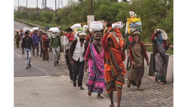 Migrant workers walk along a road to return to their villages, during a 21-day nationwide lockdown to limit the spreading of coronavirus, in New Delhi.