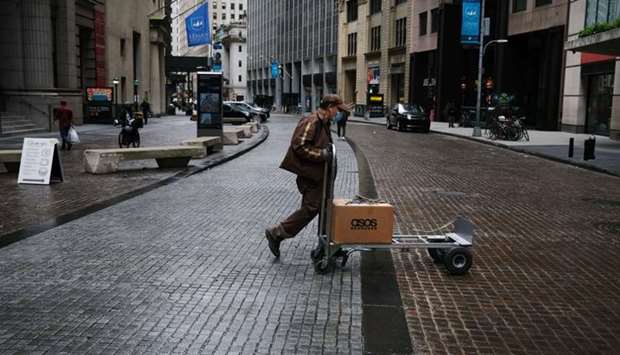 People walk in the Financial District as the coronavirus keeps financial markets and businesses mostly closed yesterday in New York City. The Bureau of Labour Statistics announced yesterday that the US economy lost 20.5mn jobs in April.