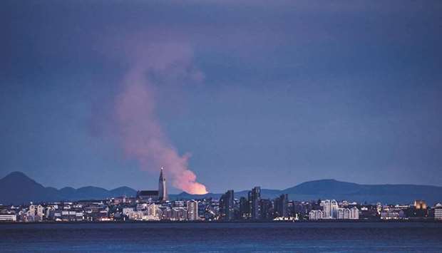 This file photo taken on May 5 shows the skyline of the Icelandic capital Reykjavik with the glow from the lava coming out of a fissure near the Fagradalsfjall on the Reykjanes Peninsula behind. (AFP)