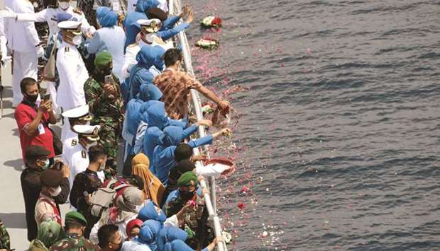 Families and colleagues of the sunken KRI Nanggala-402 submarineu2019s crew members throw flowers and petals to pay tribute during a visit at the site of its last reported dive, on the deck of Indonesian Navyu2019s KRI Dr Soeharso, in the northern waters off the island of Bali, yesterday.