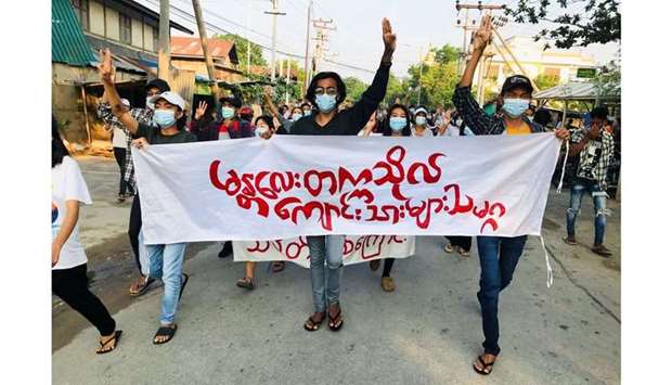 Students hold a banner and flash the three-finger salute as they take part in a protest against Myanmaru2019s junta, in Mandalay, Myanmar May 10, 2021. (REUTERS)
