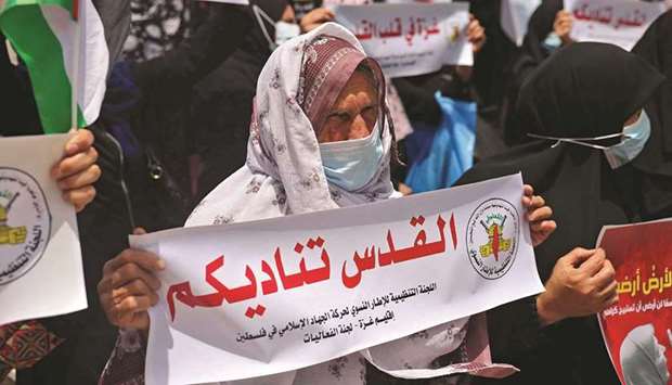 An elderly Palestinian woman stands with a sign reading in Arabic u201cJerusalem calls upon youu201d during a protest in Gaza City, yesterday, in solidarity with Palestinian families facing eviction orders in the Sheikh Jarrah neighbourhood of East Jerusalem.