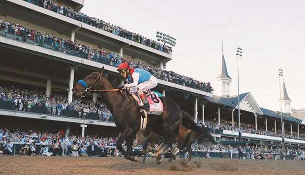 In this file photo taken on May 1, 2021, Medina Spirit, ridden by jockey John Velazquez crosses the finish line to win the 147th running of the Kentucky Derby. (AFP)