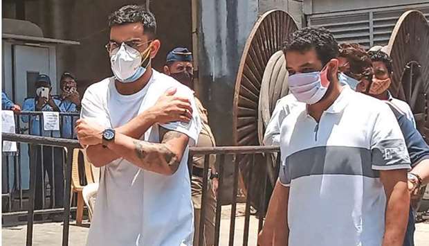 Indian cricket captain Virat Kohli clutches his arm as he walks out after receiving a dose of the Covid-19 coronavirus vaccine in Mumbai on Monday. (AFP)