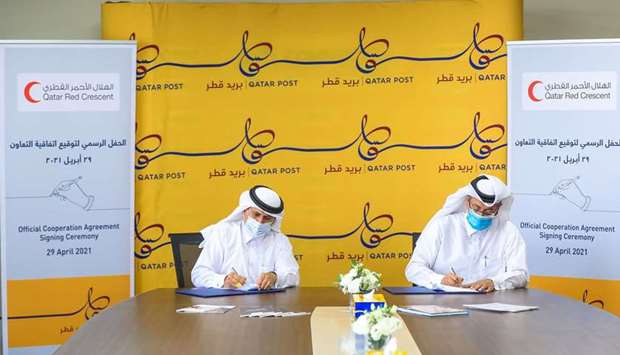 Ali bin Hassan Al-Hammadi, Secretary-General of QRCS, and Faleh al-Naemi, Chairman and Managing Director of Qatar Post, signing the pact.