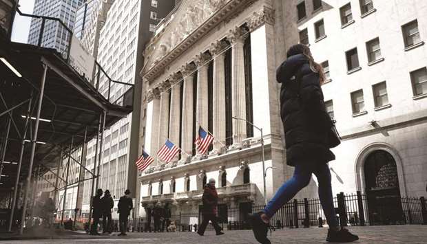 People are seen on Wall Street outside the New York Stock Exchange. US companies are leaping above expectations on first-quarter earnings, giving investors stronger confirmation that profit growth will be able to support the market this year.