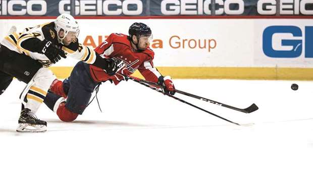 Michael Raffl (right) of the Washington Capitals shoots the puck from his knees in front of Steve Kampfer of the Boston Bruins during the second period of the game at Capital One Arena in Washington, DC, United States, on Tuesday. (AFP)