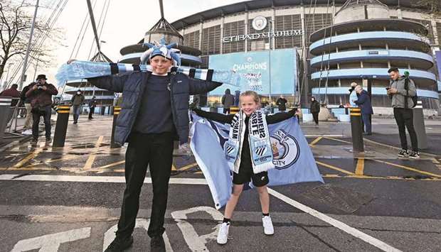 Young Manchester City fans celebrate their club winning the Premier League title, outside the Etihad Stadium in Manchester.  (AFP)