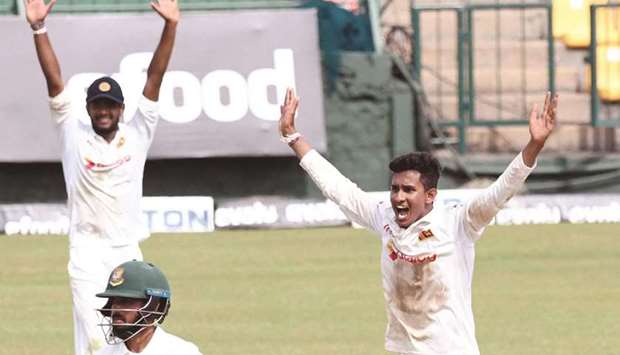 Sri Lankau2019s Praveen Jayawickrama (right) celebrates with teammates after taking the wicket of Bangladeshu2019s Mushfiqur Rahim (not pictured) during the third day of the second Test in Kandy yesterday. (AFP)