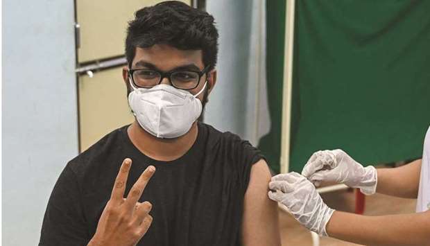 A man flashes victory sign as he gets inoculated with a dose of Covishield vaccine against Covid-19 at a vaccination centre of the Rajawadi Hospital in Mumbai, yesterday.