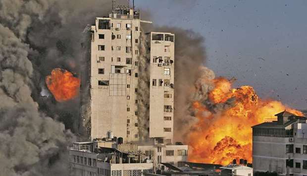 Smoke and flames rise from a tower building as it is destroyed by Israeli air strikes amid a flare-up of Israeli-Palestinian violence, in Gaza City