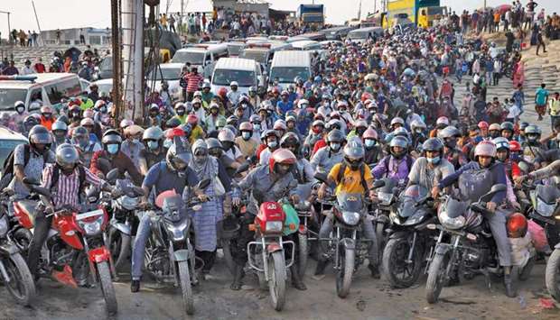 People on motorcycles rush to board a ferry at Mawa Ferry Terminal in Munshiganj, Bangladesh, to get home to celebrate Eid al-Fitr, after the government imposed Covid restrictions on long-route public transport.