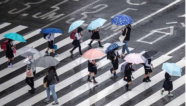 Schoolchildren cross a street on a rainy day in Tokyo