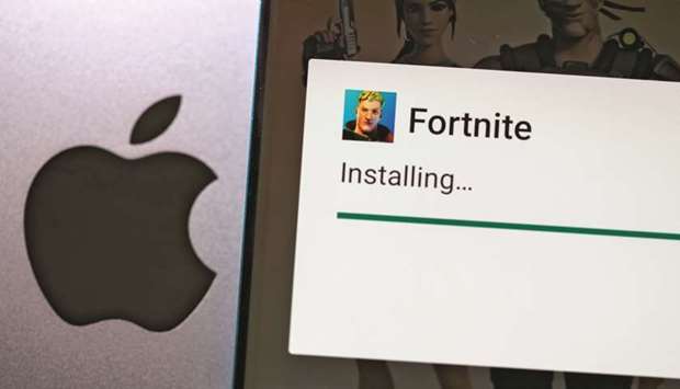 Fortnite game installing on Android operating system is seen in front of Apple logo.