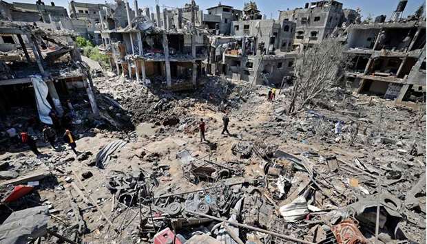 Palestinians assess the damage caused by Israeli air strikes, in Beit Hanun in the northern Gaza Strip