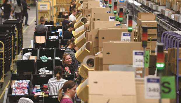 Amazon workers sort and pack items at the Amazon Fulfilment Centre in Peterborough. Amazon will hire 10,000 more people in the UK, taking its total headcount in the country to 55,000 by the end of 2021 and making the e-commerce giant one of few big employers adding jobs during the pandemic.