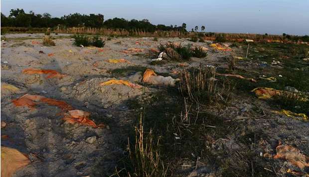 Bodies of suspected Covid-19 coronavirus victims are seen partially buried in the sand near a cremation ground on the banks of Ganges River in Rautapur Ganga Ghat, in Unnao