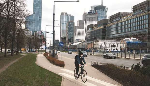 A cyclist uses a cycle lane near offices and skyscrapers in the financial district in Warsaw. The Polish government will boost spending on healthcare and housing as part of its sweeping stimulus plan u2013 financed mainly from European Union funds u2013 in an attempt to rejuvenate the economy and win back popularity.