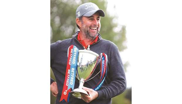 Englandu2019s Richard Bland celebrates with the trophy after winning the European Tour British Masters at the The Belfry in Sutton Coldfield, Britain, yesterday. (Reuters)