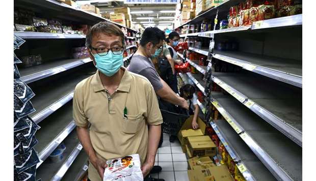 Customers rush to buy instant noodles after the government advised people to reduce leaving their homes and limit gatherings due to an increasing number of locally transmitted Covid-19 infections, in Taipei, Taiwan, yesterday.