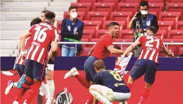 Atletico Madridu2019s Luis Suarez (centre) celebrates after scoring the winner against Osasuna during their La Liga match in Madrid, Spain, yesterday. (Reuters)