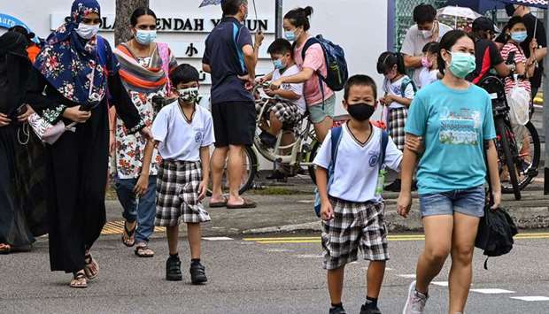 Children walk home with their guardians after school in Singapore.