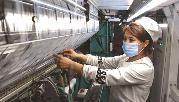 An employee works at a textile factory in Lianyungang, in Chinau2019s eastern Jiangsu province yesterday. While Chinau2019s exporters are enjoying strong demand, global supply chain bottlenecks and rising raw materials costs have weighed on production, cooling the blistering economic recovery from last yearu2019s Covid-19 slump.