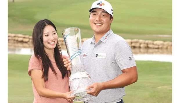Lee Kyoung-hoon of South Korea celebrates with his wife and the trophy after winning the Byron Nelson championship in McKinney, Texas, on Sunday. (AFP)