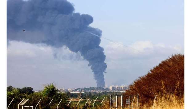 A thick column of smoke billowing in the Gaza Strip following Israeli air strikes.