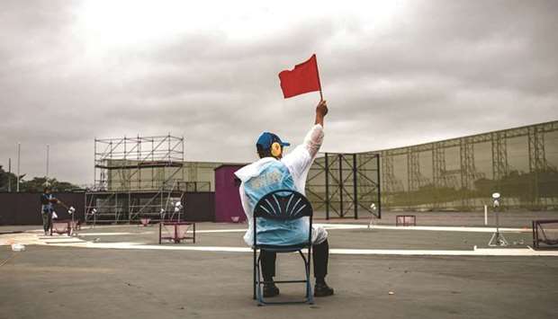 A referee holds a red flag during the skeet women and men qualification match during a test event for the Tokyo 2020 Olympic Games at Asaka Shooting Range in Nerima district of Tokyo on Tuesday. (AFP)