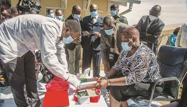 A pharmaceutical expert opens a box of expired Covid-19 AstraZeneca vaccines to show to Malawiu2019s Health Minister Khumbize Kandodo Chiponda (right) and civil society representatives and journalists before they are destroyed in a furnace at a pharmaceutical incinerator at Kamuzu Central Hospital in Lilongwe, yesterday.