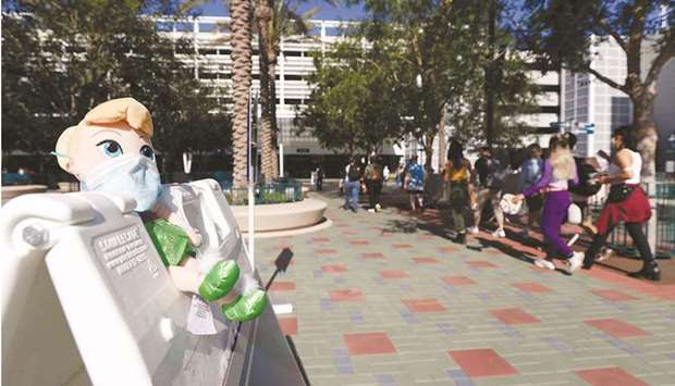 A masked Tinker Bell plush toy is seen outside Disneyland Park on its reopening day. (AFP)
