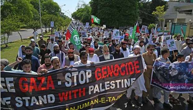 Demonstrators hold placards and shout slogans as they march in support of Palestine during an anti-Israel protest rally in Islamabad