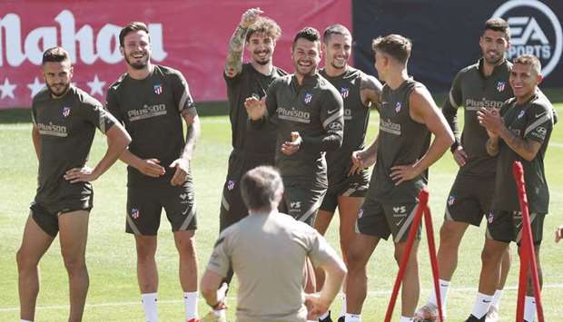 Atletico Madrid players share a light moment during a training session yesterday in Madrid. (Reuters)