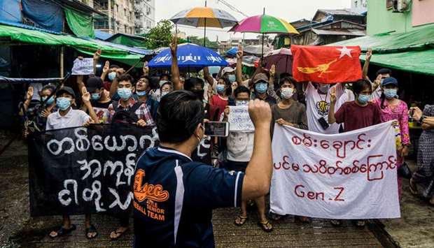 A man records protesters on his mobile phone as they take part in a demonstration against the military coup in Yangon
