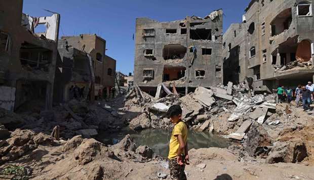 A Palestinian child stands amidst the rubble of buildings, destroyed by Israeli strikes, in Beit Hanun in the northern Gaza Strip