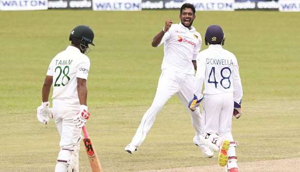 Sri Lankau2019s Ramesh Mendis (centre) celebrates after he dismissed Bangladeshu2019s Tamim Iqbal (left) during the fourth day of the second and final Test at the Pallekele International Cricket Stadium in Kandy yesterday. (AFP)