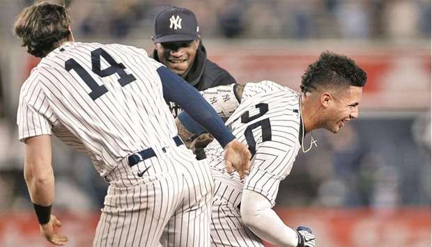 Gleyber Torres (right) of the New York Yankees celebrates with teammates after hitting a walk-off RBI single during the ninth inning against the Chicago White Sox in New York on Friday. (AFP)