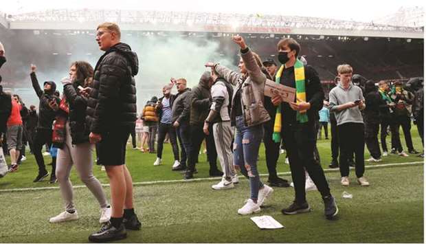 Manchester United fans protest on the pitch against club owners before the EPL match against Liverpool at Old Trafford in Manchester, England, yesterday. (Reuters)