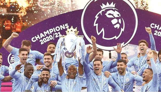 Manchester Cityu2019s players lift the Premier League trophy after their finale against Everton at Etihad Stadium in Manchester yesterday. (Reuters)
