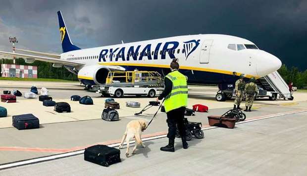 A Belarusian dog handler checks luggages off a Ryanair Boeing 737-8AS (flight number FR4978) parked on Minsk International Airport's apron in Minsk yesterday. AFP PHOTO / ONLINER.BY