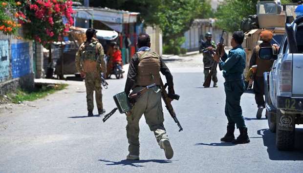 Members of Afghan security forces patrol a street during an ongoing clash between Taliban and Afghan forces in Mihtarlam, the capital of Laghman Province