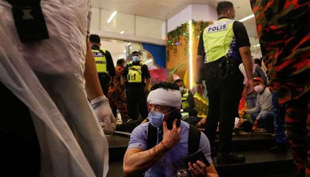 An injured passenger talking over his mobile phone outside KLCC station after an accident involving two Light Rail Transit (LRT) trains in Kuala Lumpur. AFP
