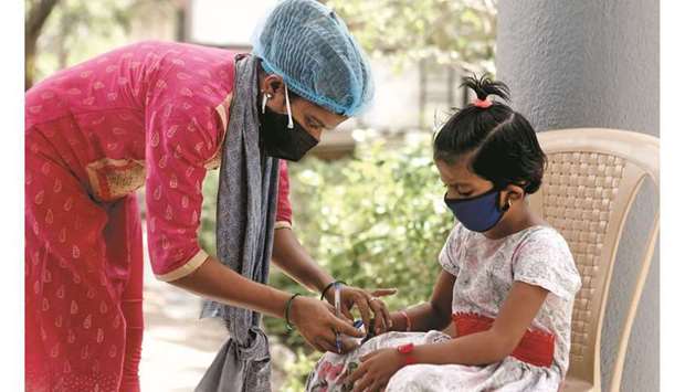 A nurse checks a coronavirus patientu2019s pulse before she is admitted into a school turned Covid-19 care facility on the outskirts of Mumbai, India.