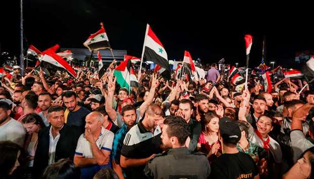 Supporters of Syria's President Bashar al-Assad celebrate the presidential election results in Damas