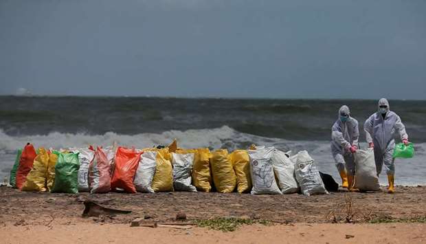 Sri Lankan navy members remove debris washed off to a beach from the MV X-Press Pearl container ship which caught fire off the Colombo Harbour, on a beach in Ja-Ela, Sri Lanka